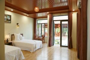 a bedroom with a bed and sliding glass doors at Son River House in Phong Nha +135 photos