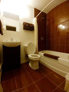 La salle de bains est pourvue de toilettes, d'une baignoire et d'un lavabo. dans l'établissement Sundown Motel, à Watrous