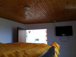 a bedroom with a bed and a flat screen tv at Hospedaje Puerta al Lago in Suse