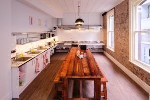 a large kitchen with a wooden table in the middle at Haka House Auckland K'Road in Auckland