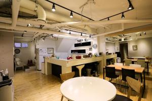 a room with tables and chairs and a kitchen at Mama Guesthouse Myeongdong in Seoul