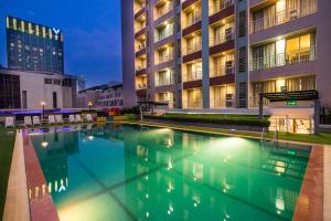 a swimming pool in front of a building at night at Evergreen Place Siam by UHG - SHA Extra Plus in Bangkok