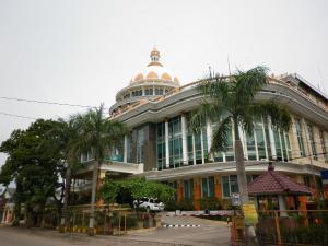 een gebouw met een palmboom ervoor bij Mega Bintang Sweet Hotel in Cepu