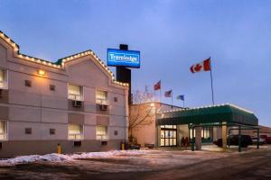 a hotel with a sign on the side of a building at Travelodge by Wyndham Winnipeg East in Winnipeg