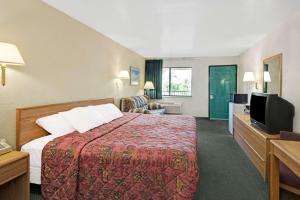 a hotel room with a bed and a flat screen tv at Days Inn by Wyndham Espanola in Espanola