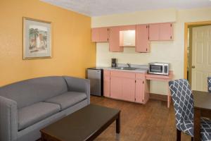 a living room with a couch and a kitchen at Days Inn & Suites by Wyndham Port Richey in Port Richey