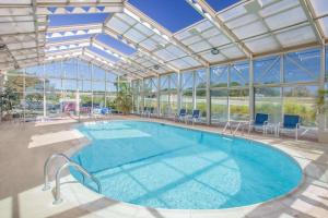 una grande piscina in un edificio con soffitto in vetro di Baymont by Wyndham Corbin a Corbin