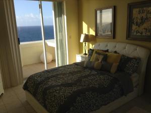 ein Schlafzimmer mit einem Bett mit Blick auf das Meer in der Unterkunft Oceanfront Home with PRIVATE POOL in Tamuning
