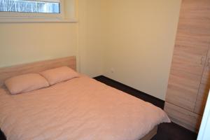 a small bedroom with a bed with a window at Živelina in Telšiai