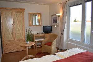 a bedroom with a desk with a computer and a bed at Alago Hotel am See in Cambs