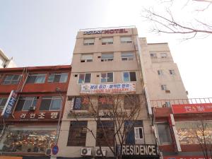 ein hohes Gebäude mit einem Schild an der Seite in der Unterkunft Hostel J Stay in Seoul