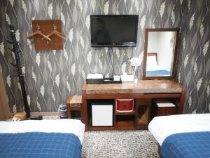 um quarto com duas camas e uma televisão e um espelho em Hostel J Stay em Seul