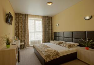 a bedroom with a large bed and a window at Hotel Marton Osharskaya in Nizhny Novgorod