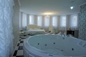 a large bathroom with a tub and a bedroom at Hotel Marton Gordeevsky in Nizhny Novgorod