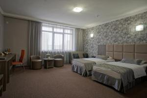 ニジニ・ノヴゴロドにあるHotel Marton Gordeevskyのベッド2台とデスクが備わるホテルルームです。