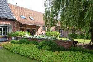 a brick house with a garden in front of it at Hotel het Elsland in Wervik