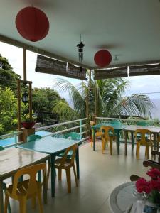 a restaurant with tables and chairs on a balcony at Susada's Inn in Oslob