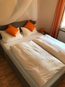 2 camas con almohadas de color naranja y blanco en un dormitorio en Ferienwohnung Gruß aus Partenkirchen en Garmisch-Partenkirchen