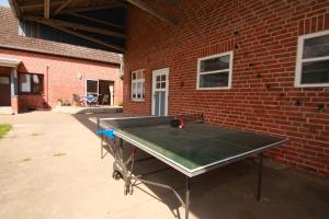 a ping pong table in front of a brick building at Ferienwohnung am Storchennest in Schnackenburg