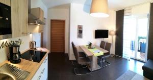 a kitchen with a table and a dining room at Residence Reinhild in Nalles