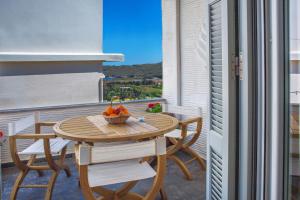 a table on a balcony with a bowl of fruit on it at Philoxenia Anemomilos in Andros