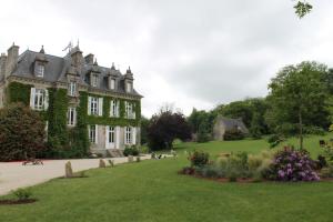 an old mansion with a green lawn in front of it at Manoir de Kerangosquer in Pont-Aven