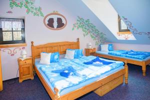 - 2 lits dans une chambre avec des draps bleus dans l'établissement Borovansky mlyn, à Borovany