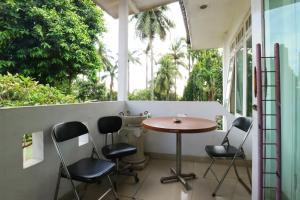 una mesa pequeña y sillas en un balcón con árboles en Villa Sri Manganti en Yakarta
