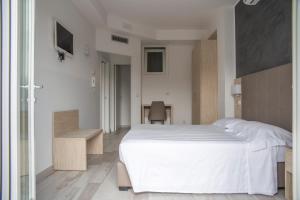 a bedroom with a large white bed and a desk at Rooms A due Passi dal Mare in Porto Recanati