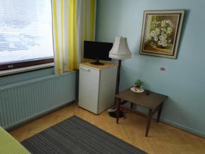 Habitación con TV y mesa con lámpara. en Guesthouse Outa en Rovaniemi