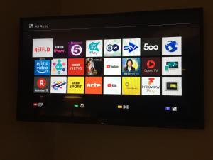a television screen with a bunch of logos on it at Central City Garden Apartment in Cardiff
