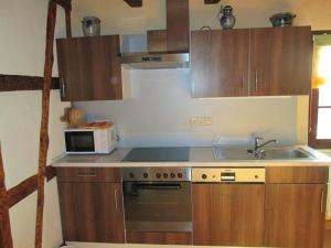 eine kleine Küche mit einer Spüle und einer Mikrowelle in der Unterkunft Ferienhof Seeber in Weikersheim