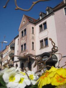 a tall building with a bunch of flowers in front of it at Hotel Walfisch in Würzburg