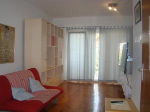 a living room with a red couch and a window at Villa Lipa in Zadar