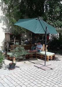 two people sitting on a bench under an umbrella at Ferienhof Seeber in Weikersheim