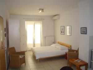 a bedroom with a white bed and a window at Villa Lipa in Zadar