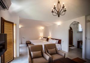 a bedroom with a bed and two chairs and a chandelier at Oasis Hotel in Magong