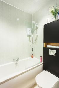 a bathroom with a shower and a toilet and a tub at Neptunes Rest Guest Hotel in Stranraer