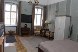 a bedroom with a bed and a living room at Cozy Loft Apartman in Eger