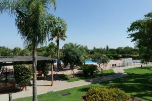 uma vista para um resort com uma piscina e palmeiras em Prado Golf by Ĥ em Isla Canela