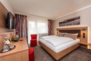 a hotel room with a bed and a desk and a television at Hotel Bären in Rottweil