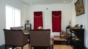 a living room with red curtains and a piano at Villa Cipanas in Tjiandjur