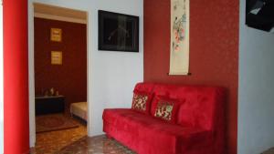 a red couch in a room with a red wall at Villa Cipanas in Tjiandjur