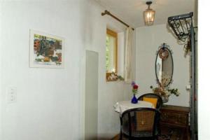 una stanza con tavolo, sedie e specchio di Studio in Chasa Quirin a Zernez
