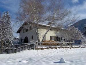 una casa con una recinzione nella neve di Studio in Chasa Quirin a Zernez