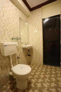 a bathroom with a toilet and a sink at Motel La Grandeur in Mapusa