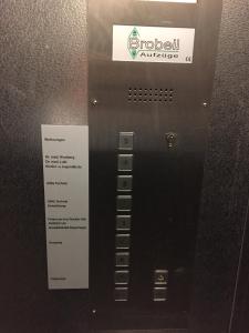 Un ascensor negro con una señal. en Pension QMT Reutlingen, en Reutlingen