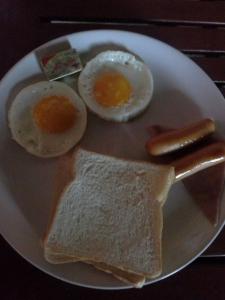 a plate with two eggs and a piece of toast at Tamarind Grand Resort Mae Sariang in Mae Sariang