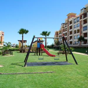 a playground with a swing set in a park at Los Cisnes by HOMA in Isla Canela