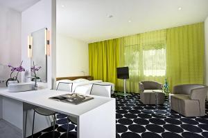 a living room with a white counter and a green curtain at Tryp by Wyndham Frankfurt in Frankfurt/Main